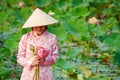 The girl is wearing Vietnamese clothes, wearing a hat and holding lotus flowers. Royalty Free Stock Photo