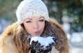 Girl Wearing Warm Winter Clothes And Hat Blowing Snow Royalty Free Stock Photo