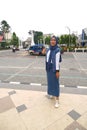 A girl wearing a white and blue dress stands in front of the Zero Kilometer Point in Central Surakarta City
