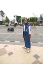 A girl wearing a white and blue dress stands in front of the Zero Kilometer Point in Central Surakarta City