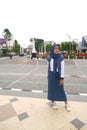 A girl wearing a white and blue dress stands in front of the Zero Kilometer Point in Central Surakarta City