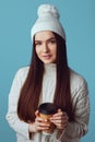 Girl wearing white hat and sweater, enjoys drinking coffee from takeout cup Royalty Free Stock Photo