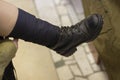A girl wears a military shoe. The girl ties the shoelaces on her leg Royalty Free Stock Photo
