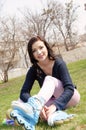 Girl wears roller skates sitting on the grass. Royalty Free Stock Photo