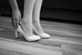 The girl wears a Shoe on the leg. Bride puts his shoes in the morning in the interior Royalty Free Stock Photo