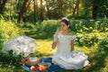 Girl in a wedding dress in the park on a sunny day on a picnic with Royalty Free Stock Photo