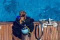 Girl in a wetsuit and scuba gear sits on the deck of a yacht Royalty Free Stock Photo