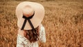 Girl wheat field summer. Happy young woman in sun hat in summer wheat field at sunset. Nature, summer holidays, vacation