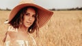 Girl wheat field summer. Happy young woman in sun hat in summer wheat field at sunset. Nature, summer holidays, vacation