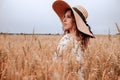 Girl wheat field summer. Happy young woman in sun hat in summer wheat field at sunset. Nature, summer holidays, vacation