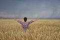 Girl in a wheat field before a thunderstorm