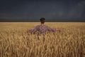 Girl in a wheat field before a thunderstorm