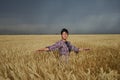 Girl in a wheat field before a thunderstorm