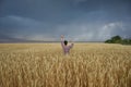 Girl in a wheat field before a thunderstorm