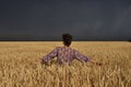 Girl in a wheat field before a thunderstorm