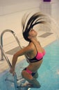 Girl whipping her hair back in the pool and spraying water everywhere splash