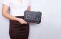 Girl on a white background holding a sign with the inscription infant, female infertility, copy space, fertility