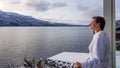 Austria - A girl in a white bathrobe standing on the balcony in winter