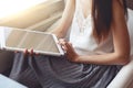 Girl in white blouse and grey skirt using tablet idoors Royalty Free Stock Photo