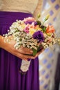 A girl in a white blouse and purple skirt holds in her hands a beautiful festive bouquet Royalty Free Stock Photo