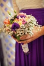 A girl in a white blouse and purple skirt holds in her hands a beautiful festive bouquet Royalty Free Stock Photo