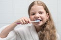 Girl in white coat brushing her teeth, close-up Royalty Free Stock Photo