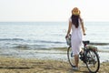 Girl with a bicycle on the seashore, back view