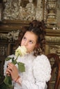 Girl in a white dress with a hairstyle in retro style with flowers in her hands Royalty Free Stock Photo