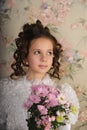 Girl in a white dress with a hairstyle in retro style with flowers in her hands Royalty Free Stock Photo