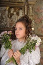 Girl in a white dress with a hairstyle in retro style with flowers in her hands Royalty Free Stock Photo