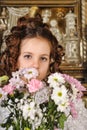 Girl in a white dress with a hairstyle in retro style with flowers in her hands Royalty Free Stock Photo