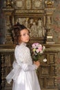 Girl in a white dress with a hairstyle in retro style with flowers in her hands Royalty Free Stock Photo