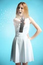 girl in a white dress holding a bottle with hairspray