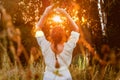 The girl in a white dress looks at the sunset in the forest and relaxes. Woman with braid hairstyle meditation