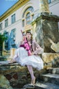 Girl in a white dress with a pink rifle plays airsoft Royalty Free Stock Photo