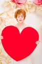 Girl in white dress with red heart in hands Royalty Free Stock Photo