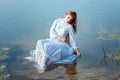 Girl white dress sitting on chair in a lake. Royalty Free Stock Photo