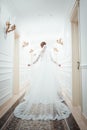 A girl in a white dress walking along a white corridor. Beautiful fashion girl walking along the corridor in a dress. Dress from