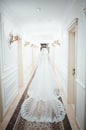 A girl in a white dress walking along a white corridor. Beautiful fashion girl walking along the corridor in a dress. Dress from