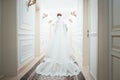 A girl in a white dress walking along a white corridor. Beautiful fashion girl walking along the corridor in a dress. Dress from