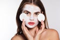 Girl with white face pack and cotton pads in hands Royalty Free Stock Photo