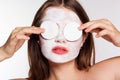 Girl with white face pack and cotton pads in hands Royalty Free Stock Photo