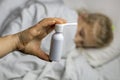 A girl with white hair lies in bed she is out of focus. mom using an inhaler makes an injection in the patient`s throat, she is i Royalty Free Stock Photo
