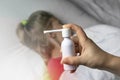 A girl with white hair lies in bed she is out of focus. mom using an inhaler makes an injection in the patient`s throat, she is i Royalty Free Stock Photo