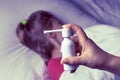 A girl with white hair lies in bed she is out of focus. mom using an inhaler makes an injection in the patient`s throat, she is i Royalty Free Stock Photo