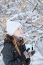 Girl in a white hat with cup of tea. Winter, outdoors. Side view Royalty Free Stock Photo
