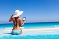 Girl with white hat reads kindle on beach Royalty Free Stock Photo