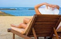 Girl in white hat sitting in chaise longue