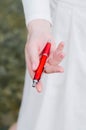 A girl in white holds books in a red cover in her hands on books lies a red penthe girl in white holds books in a red cover in her