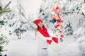 A girl in a white jacket throws Christmas balls to decorate the Christmas tree.A girl throws Christmas decorations from